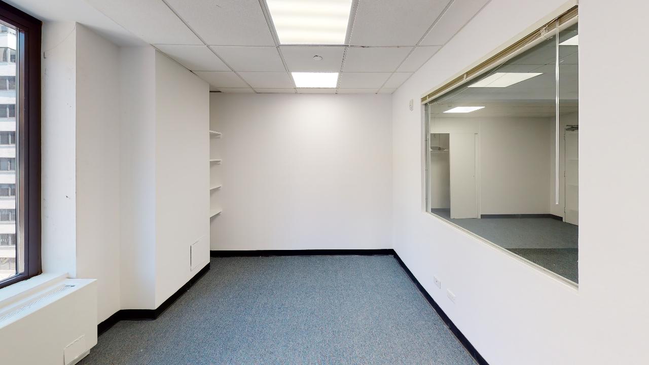 353 Lexington Avenue Office Space with white walls, gray carpet, large window on left.