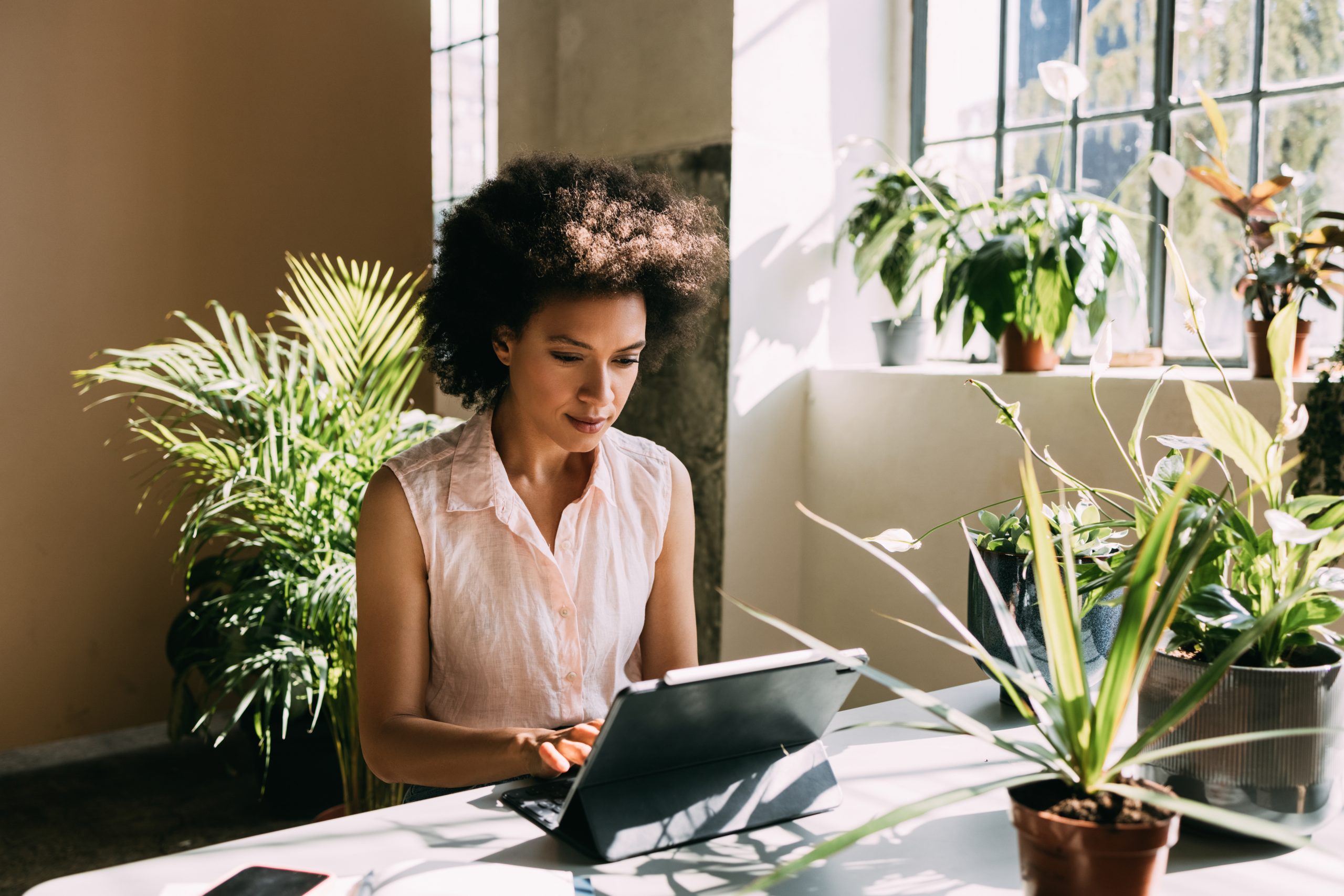 Businesswoman in a green office space, embodying sustainability in NYC's commercial real estate.