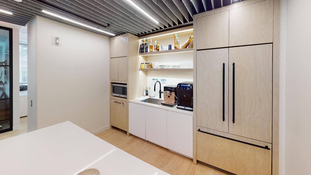 Modern kitchen in Suite #1202, 250 Park Ave, with light wood cabinets.