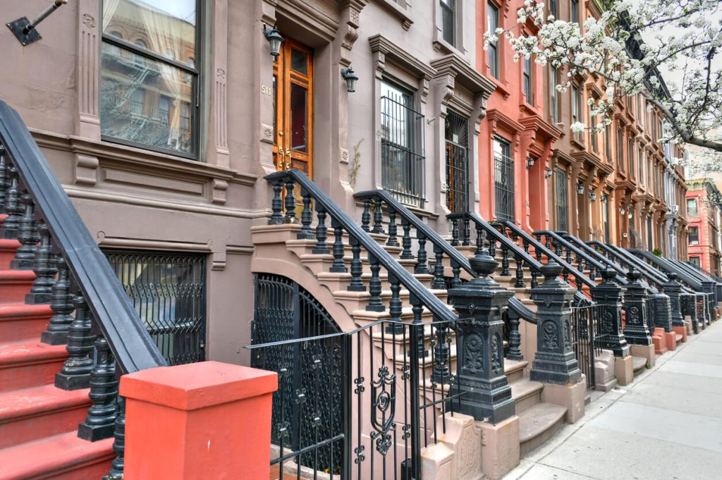 Street view of brownstone buildings in Harlem, New York City.