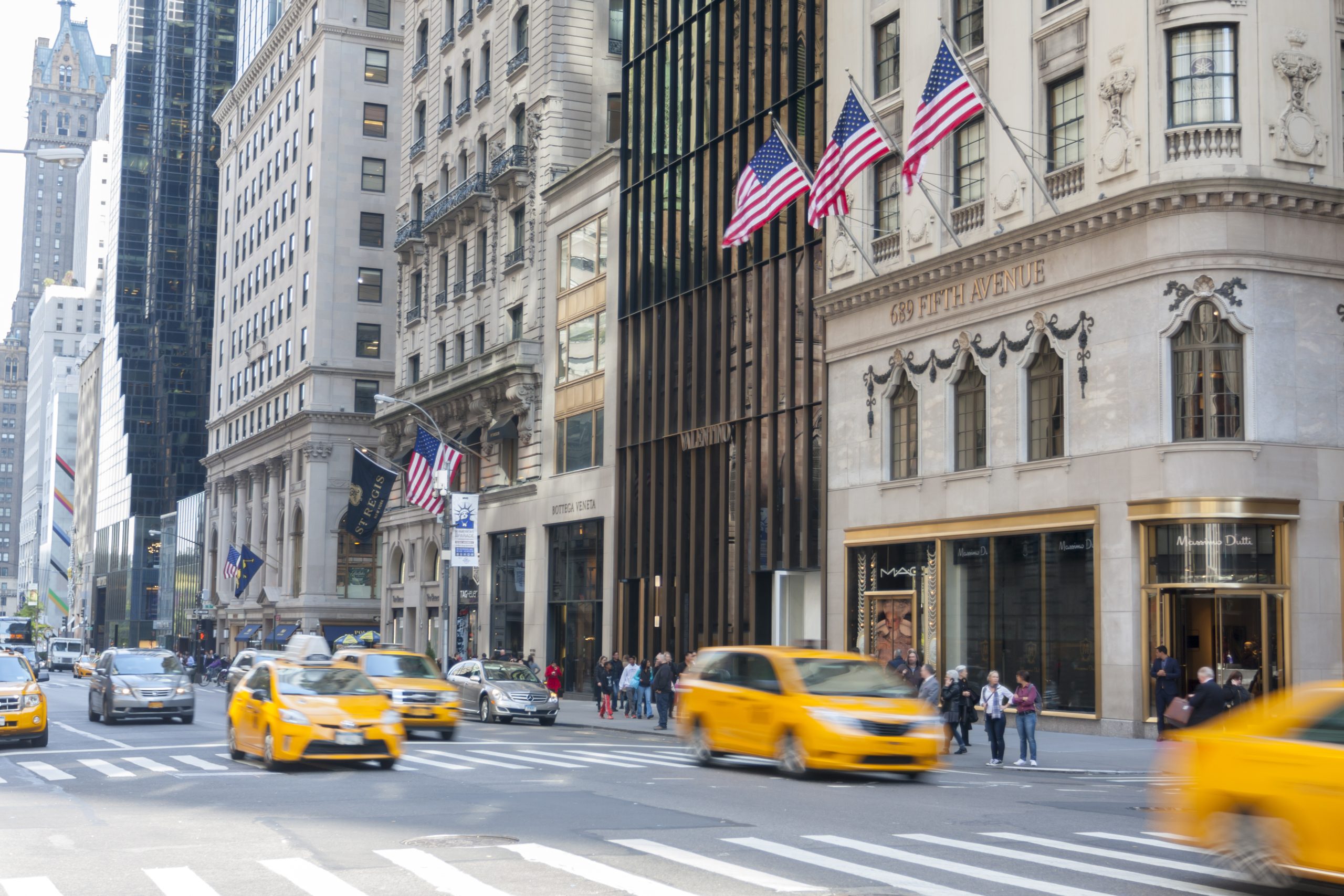 A photo of New York's 5th Avenue, with multiple luxury stores visible in the background.