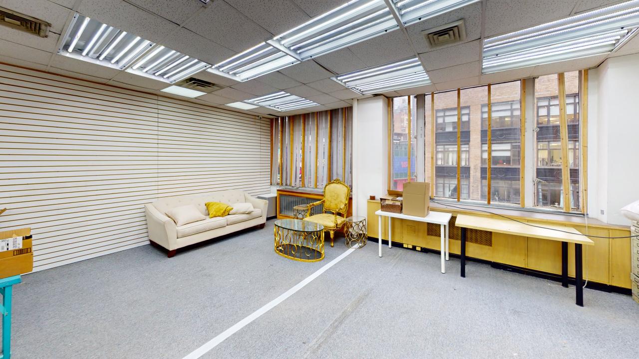 Suite #302 at 1220 Broadway is a bright room featuring a large window wall, allowing natural light to fill the space.