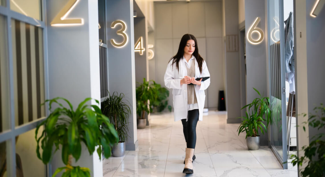 Healthcare worker with tablet at NYC clinic corridor