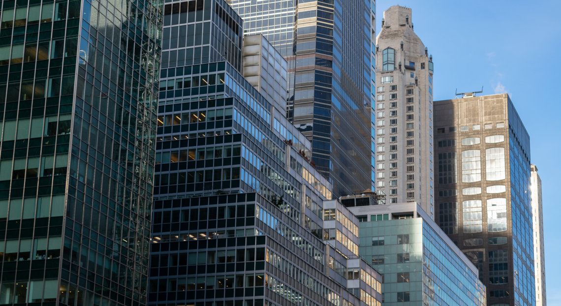Looking up at a row of glass office buildings on Park Avenue in Midtown Manhattan, New York City