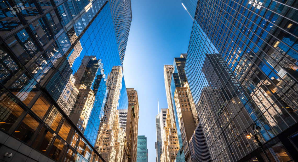 Skyscrapers with glass facades reflecting a dynamic urban scene.