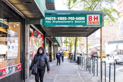 People outside a store with green awning reading