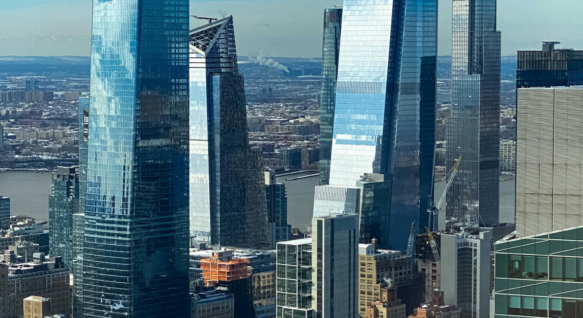 Modern glass skyscrapers in NYC's Hudson Yards on a clear day.