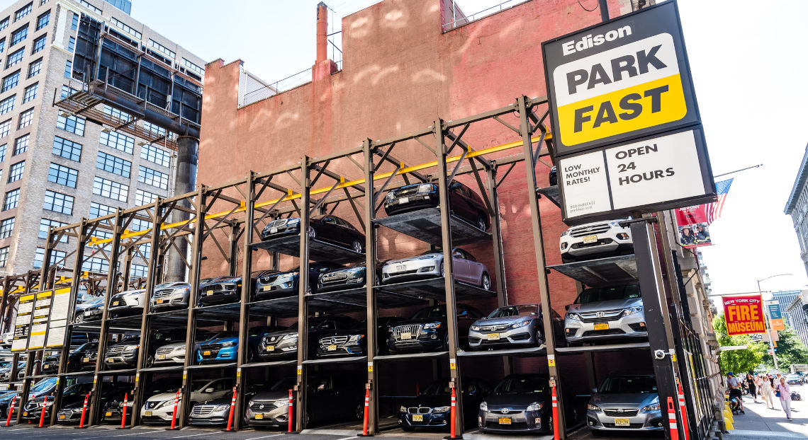 Multi-level car parking structure with cars and Edison Park Fast sign.