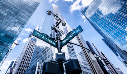 6th Ave and W 42nd St street signs with glass skyscrapers in New York City.